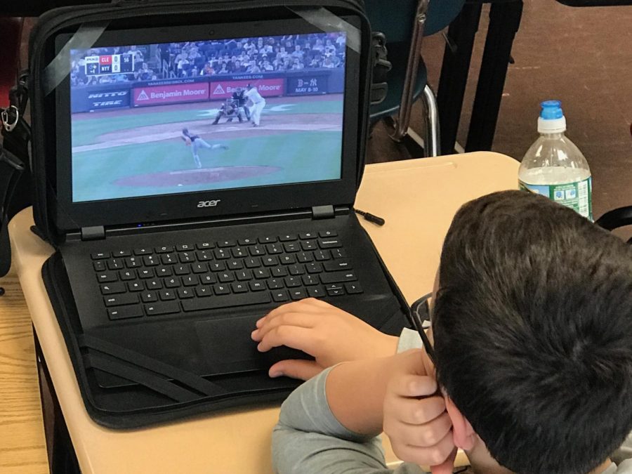 Sixth grade student, Patrick Walsh, watches Yankees highlights on his laptop. The Yankees have hit 79 home runs this season - an impressive start for this early in the regular season.
