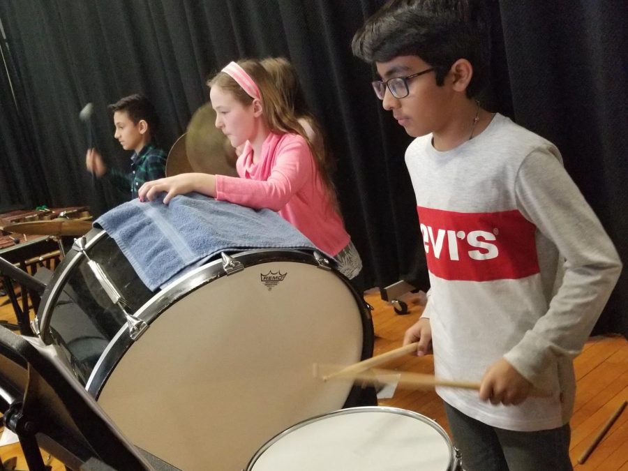 The Concert band boasts a loud percussion group. These students are playing the marimba, bass drum and snare drum.