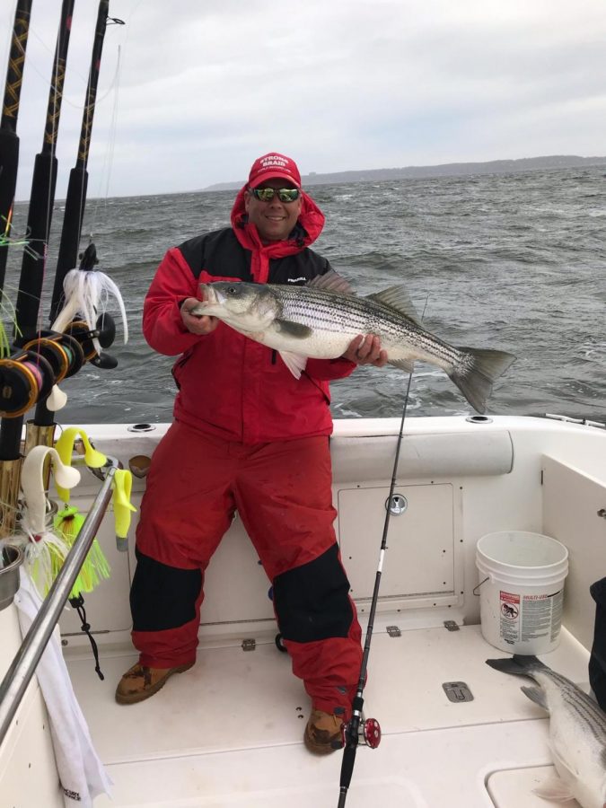 Kris Lechman proudly shows off his catch - a striped bass fish. It was one of ten huge bass fish caught on this day.