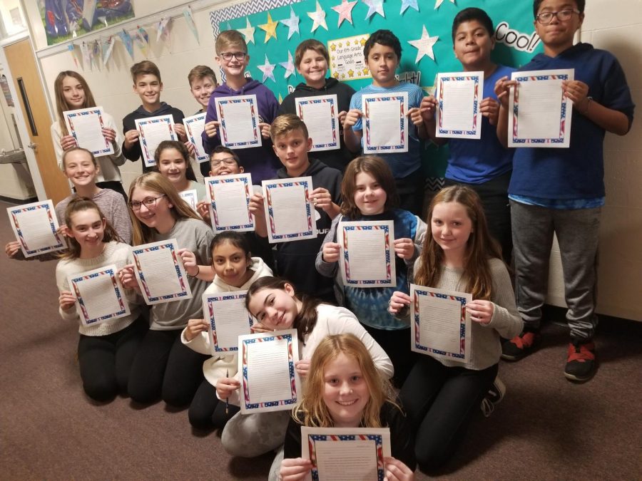 Sixth+grade+students+voted+to+write+letters+of+repsect+to+various+community+members+as+their+Week+of+Respect+yearlong+project.+These+students+from+Mrs.+April+Catuognos+class+display+their+letters+to+military+men+and+women+written+in+the+month+of+November.