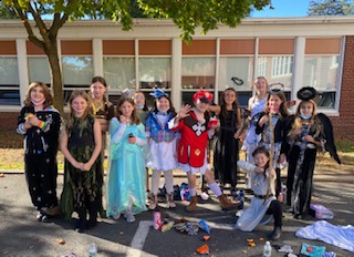 Students gather in the courtyard during snack time dressed in Halloween costume.