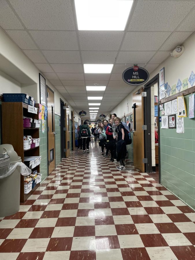 Fifth-graders wait outside their homeroom door for the day to begin.