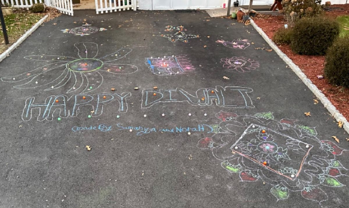 This shows a colorful driveway displaying decorations made with chalk and rangoli during a Diwali celebration in Emerson, New Jersey.                                                                         