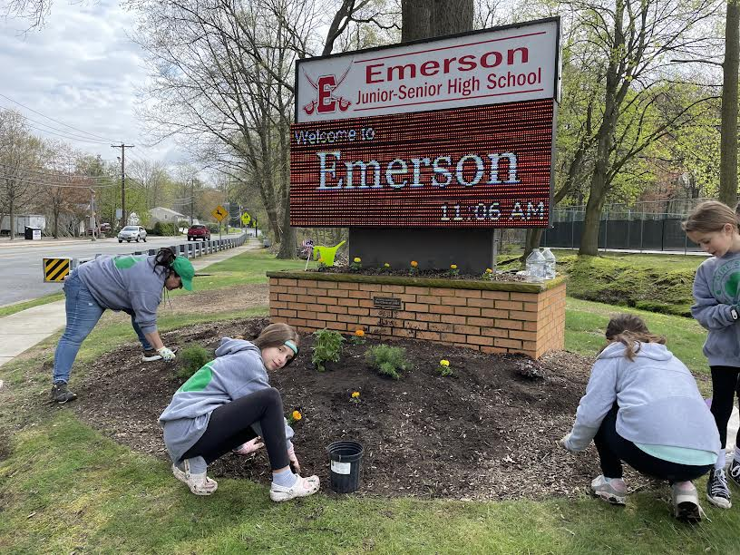 Local Girl Scouts add flowers and remove weeds from the grounds of Emerson Junior-Senior High School in honor of Earth Day.