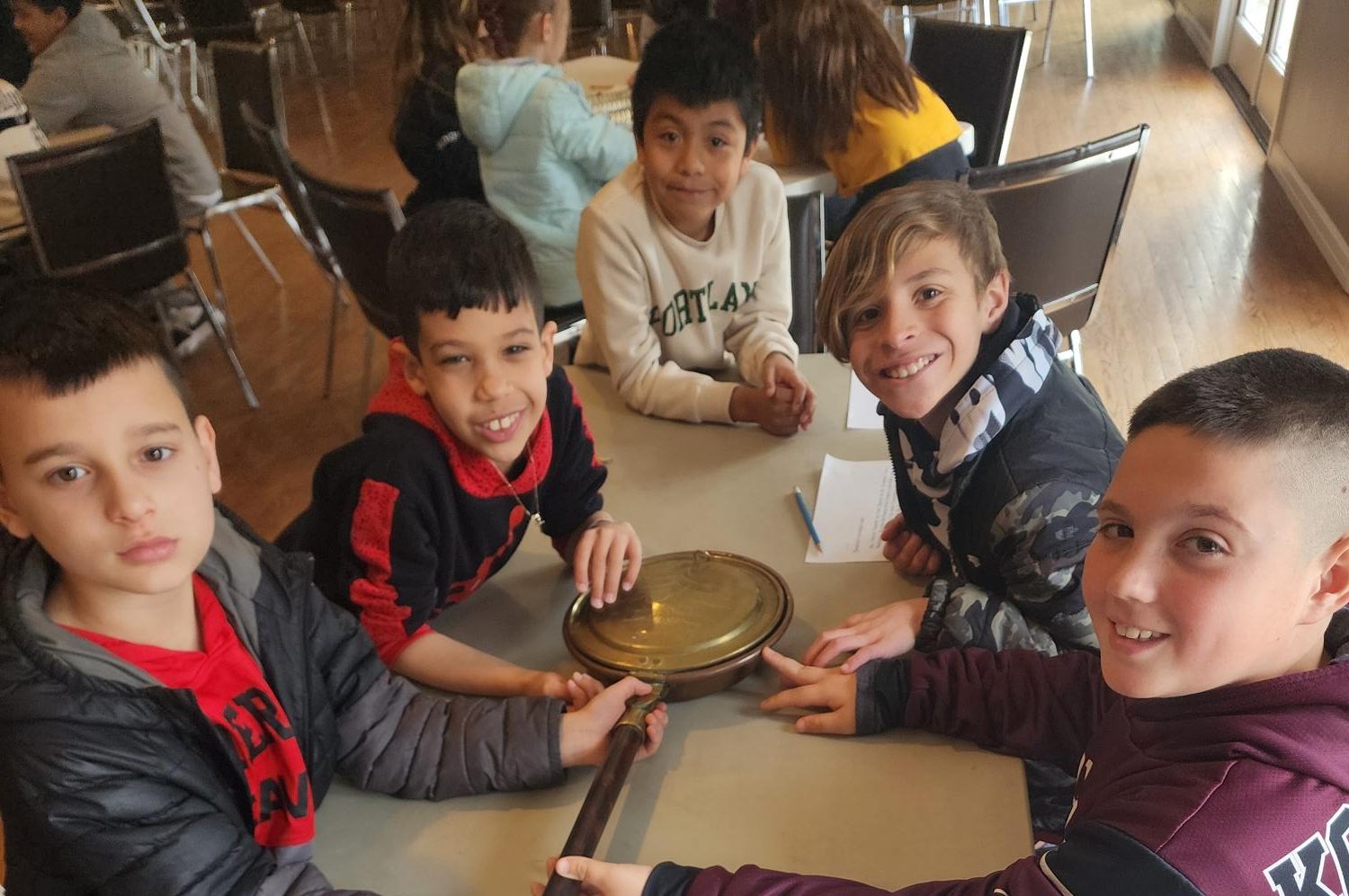 Fourth graders hold a colonial popcorn maker. It was one of several artifacts they explored at The Hermitage.