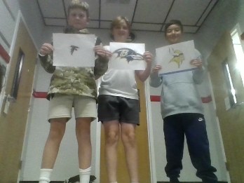 These sixth graders are football fanatics. They're holding the logos of the NFL teams that won their most recent games.