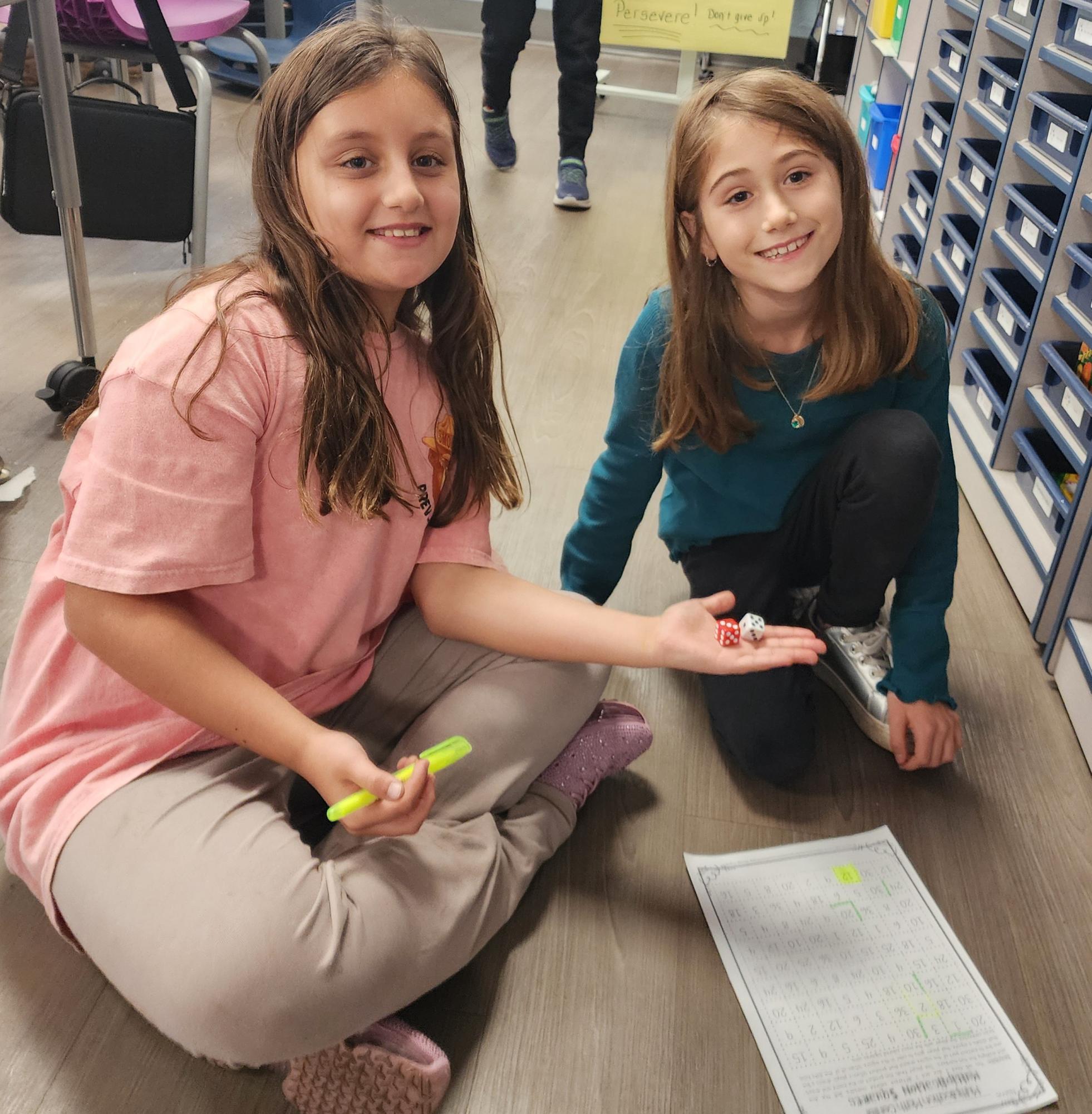 These fourth graders are playing a cooperative dice game to work on their multiplication skills.