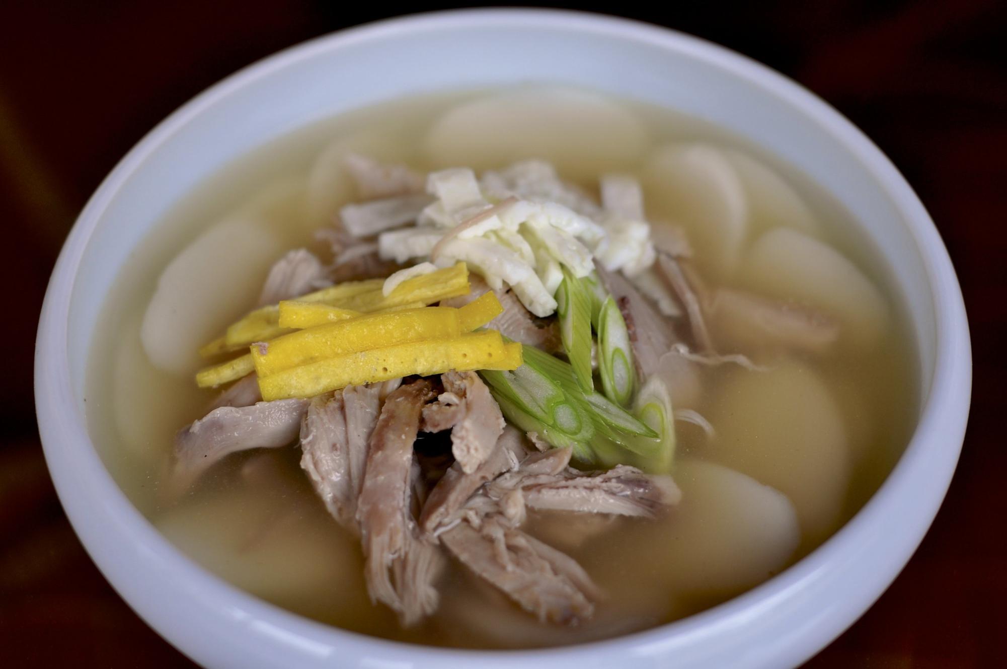 This is a traditional rice cake soup eaten on Lunar New Year. https://www.flickr.com/photos/40726522@N02/page3