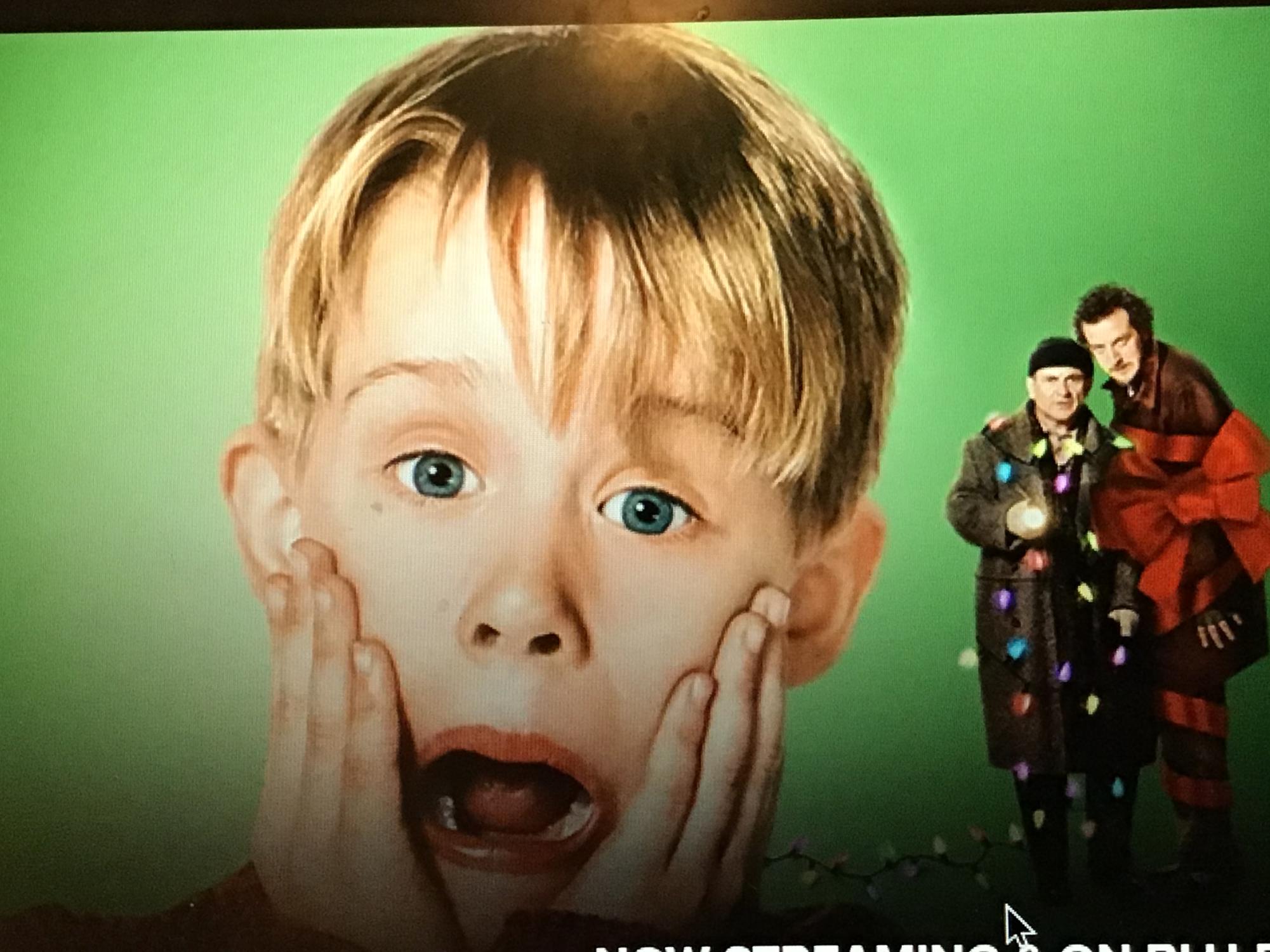 This is the main character, Kevin, friom the movie Home Alone. Kevin is surprised as the home burglars just got tangled in holiday lights and Christmas decorations.
