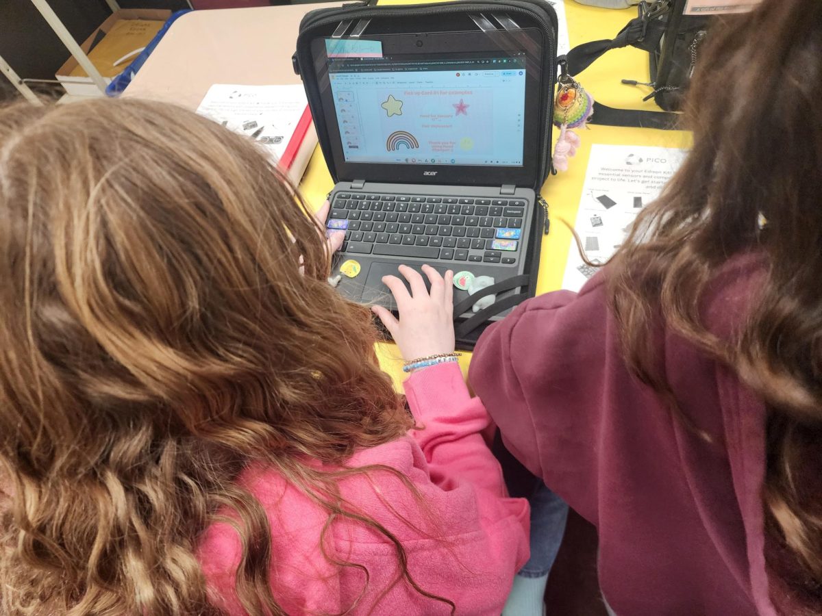 These fifth-grade students use their Chromebook to research how to make an app. The work is supervised by a teacher.